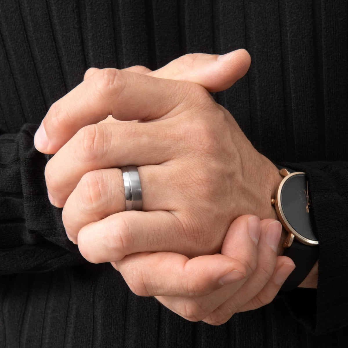 Bague Ravenstone en tantale bleu antarctique brossé avec bord lisse brillant, portée à la main dans une scène sombre et minimaliste.